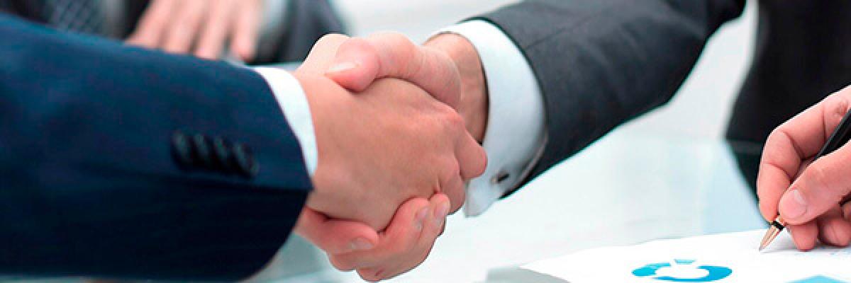 Préstamo Inversión - Dos hombre se dan la mano en una reunión en la oficina