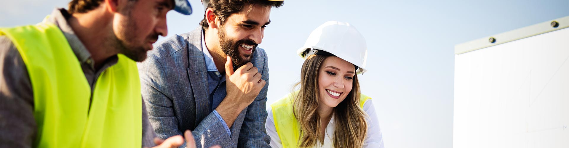 Seguro de Todo Riesgo Construccion - Grupo de arquitectos y trabajadores de construccion trabajando juntos frente a un plano de un edificio