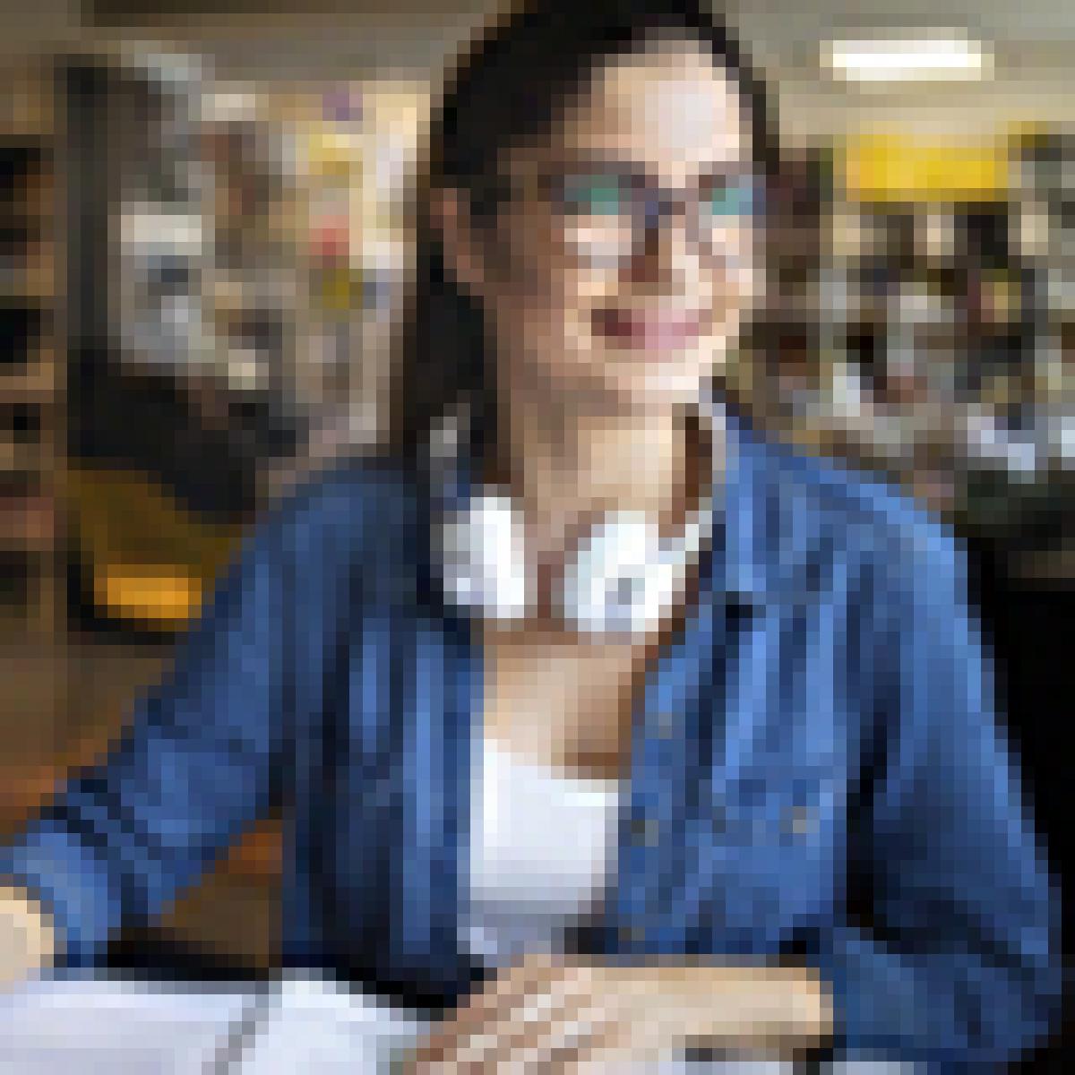 Tienes todo por delante - Chica universitaria con gafas y cascos de música estudiando en la biblioteca