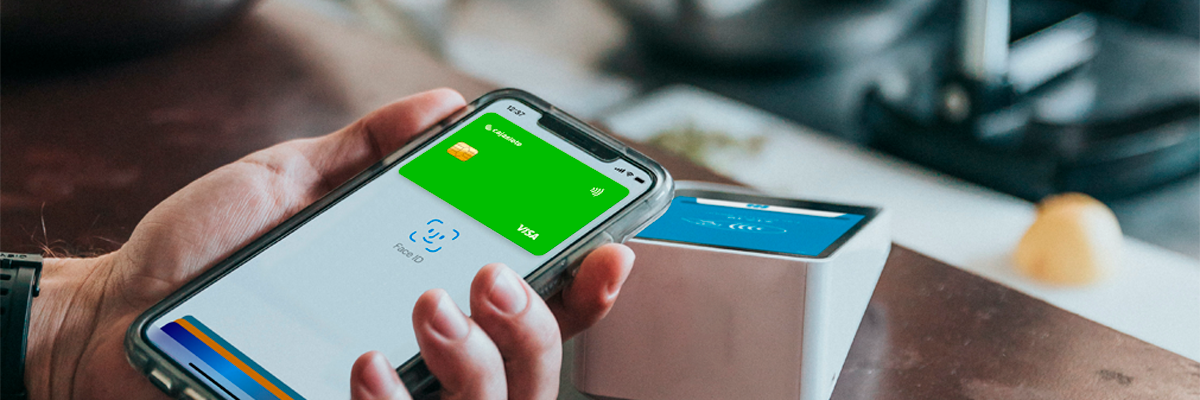 Apple Pay - Persona pagando con apple pay en su movil en el tpv de un comercio Apple Pay - Persona pagando con apple pay en su movil en el tpv de un comercio